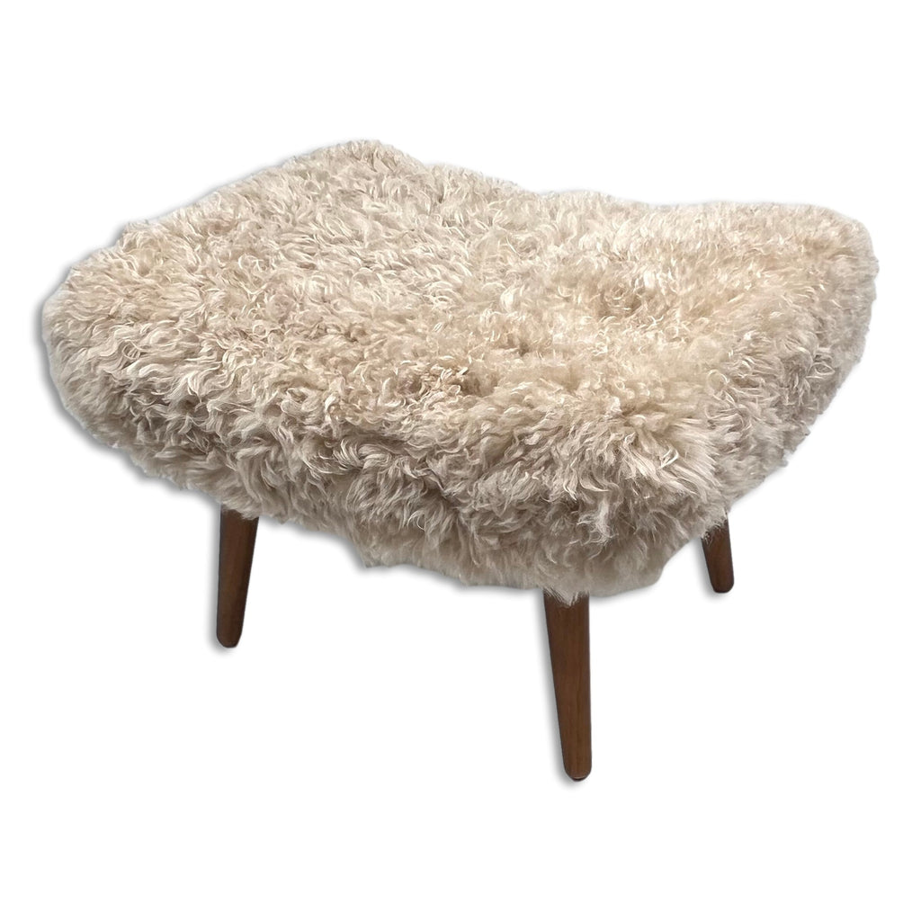Beige Shearling Sheepskin Footstool styled in living room as luxury accent